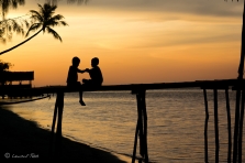 Les enfants jouant sur la jetée lors du coucher de soleil à Yenkoranu Homestay, sur Kri Island.